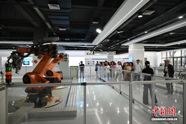 图为9月7日，越南游客在重庆市两江新区参观工业机器人。张旭 摄